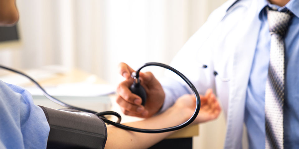 male healthcare provider using stethoscope on male patient